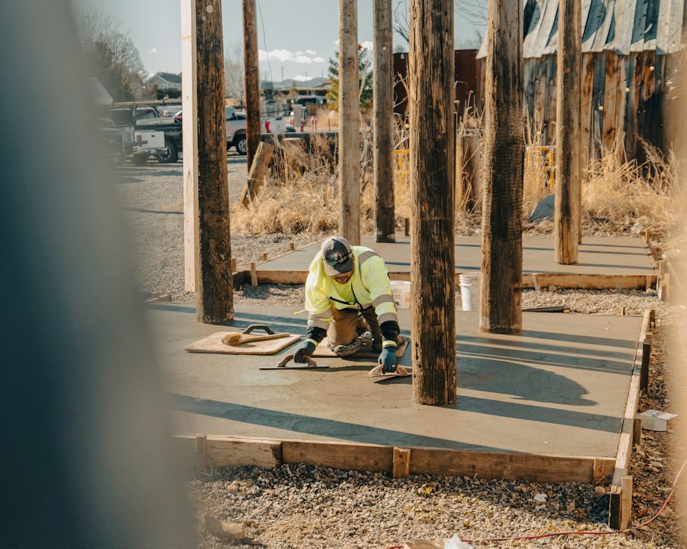 A tradesman finishing a fresh concrete slab (stock photo)
